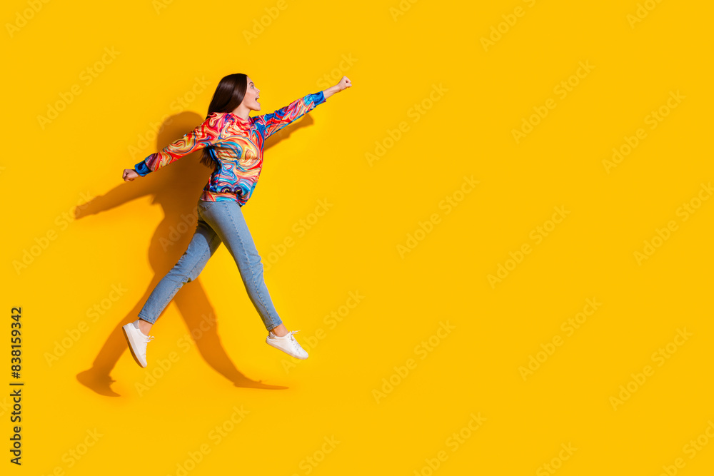 Full length photo of lovely young lady flying superhero dressed stylish colorful garment isolated on yellow color background
