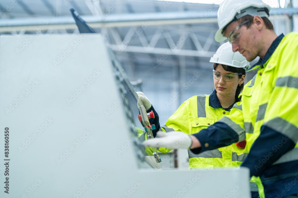 Male and female engineers in neat work clothes prepare and control the production system of large modern machines in a factory producing industrial technology products. Male and female engineers in neat work clothes prepare and control the production system of large modern machines in a factory producing industrial technology products.