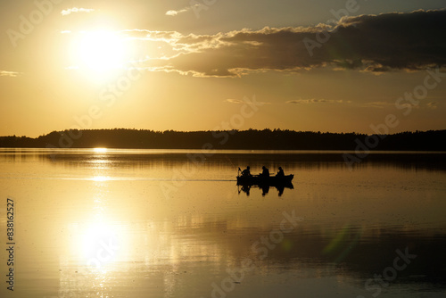 Fototapeta Naklejka Na Ścianę i Meble -  Scenic sunset over lake with boat silhouette - Masuria, Poland