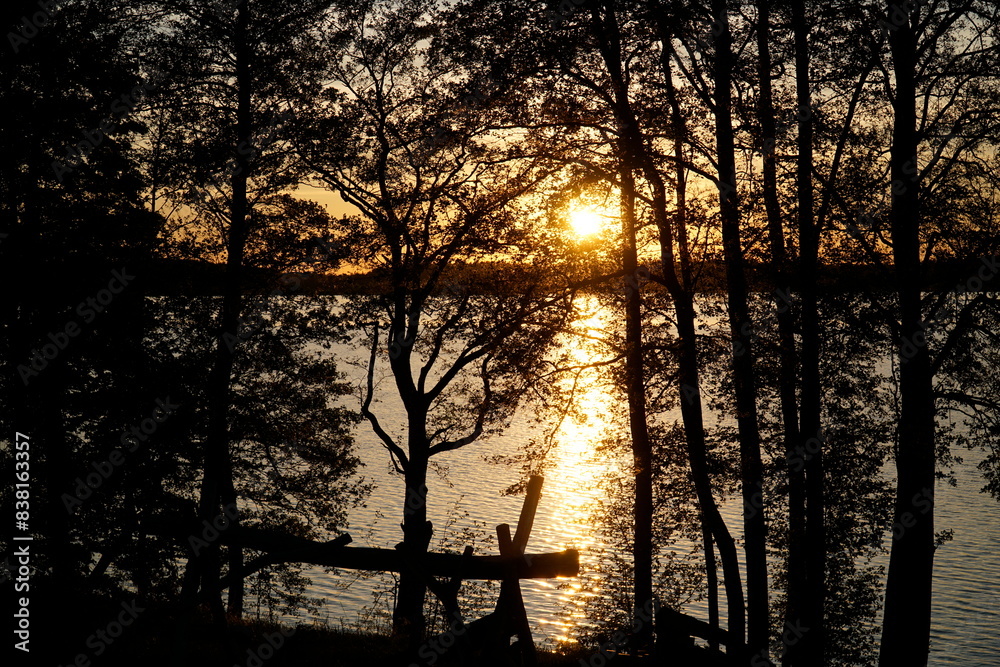 Sunset over lake with trees at shore Sunset over lake with trees at shore