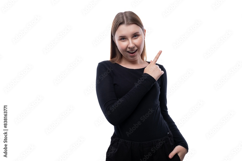 European fair-haired teenage girl dressed in a black turtleneck shows her finger European fair-haired teenage girl dressed in a black turtleneck shows her finger