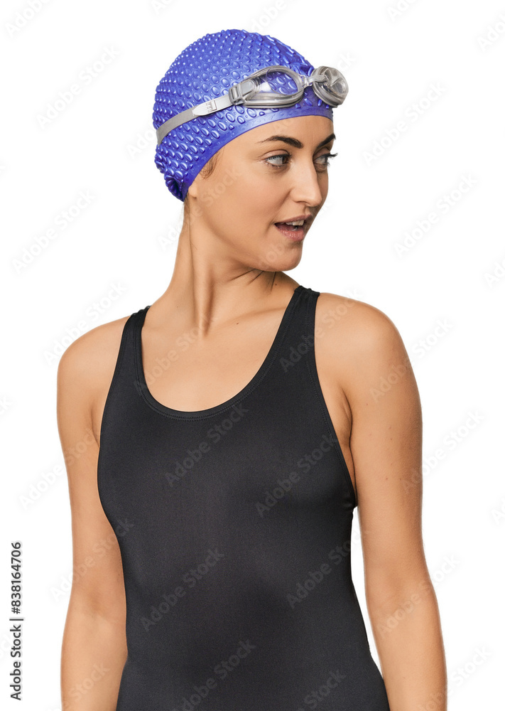 Young Caucasian female professional swimmer looks aside smiling, cheerful and pleasant. Young Caucasian female professional swimmer looks aside smiling, cheerful and pleasant.