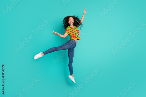 Full body photo of pretty young girl jump dance ballet wear trendy striped outfit isolated on aquamarine color background