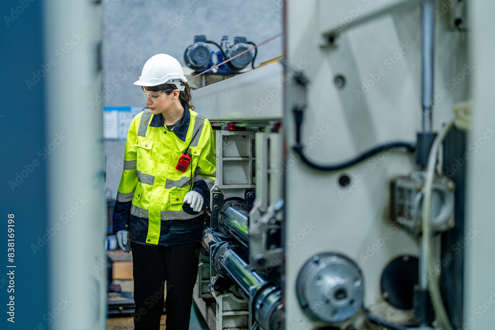 female engineers in neat work clothes prepare and control the production system of large modern machines in a factory producing industrial technology products. female engineers in neat work clothes prepare and control the production system of large modern machines in a factory producing industrial technology products.
