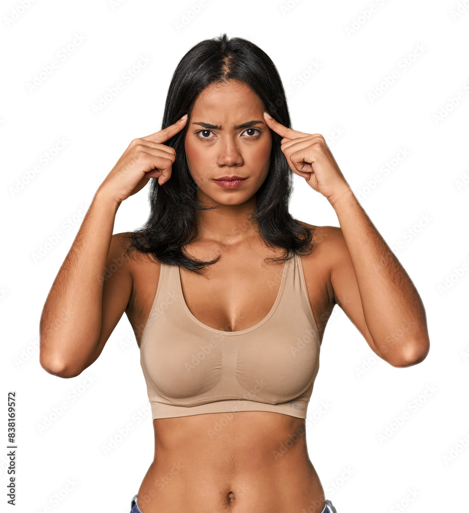 Young Filipino woman in light wear focused on a task, keeping forefingers pointing head. Young Filipino woman in light wear focused on a task, keeping forefingers pointing head.