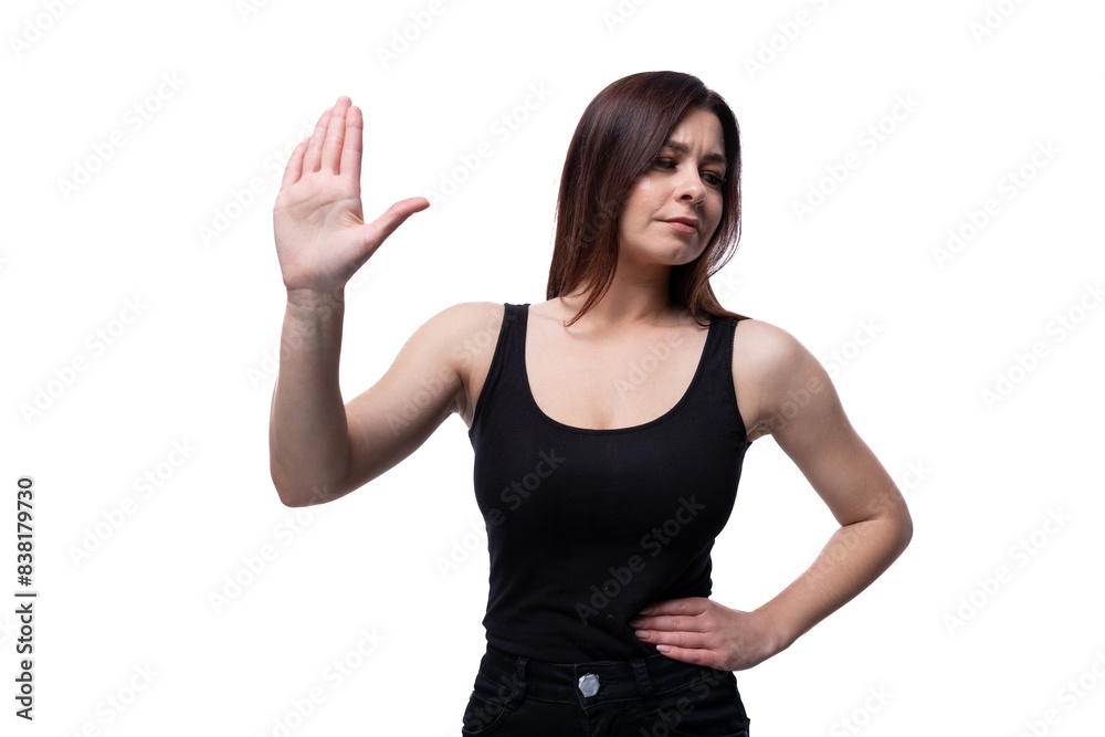 Young stylish woman with black hair wearing a black off-shoulder T-shirt on a white background Young stylish woman with black hair wearing a black off-shoulder T-shirt on a white background