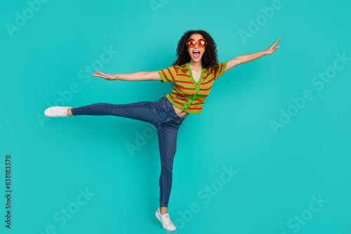 Full length photo of lovely young lady flying enjoy summer dressed stylish striped garment isolated on cyan color background