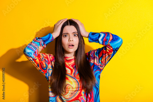 Photo portrait of attractive teen woman touch head scared dressed stylish colorful clothes isolated on yellow color background