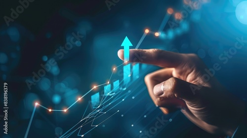 Businessperson's hand pointing at a digital graph arrow moving upward, signaling positive momentum and advancement