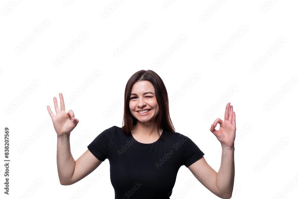 Young confident woman with black hair dressed in a black T-shirt shows her hands up Young confident woman with black hair dressed in a black T-shirt shows her hands up