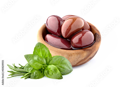 Red olives in wooden bowl on white background.