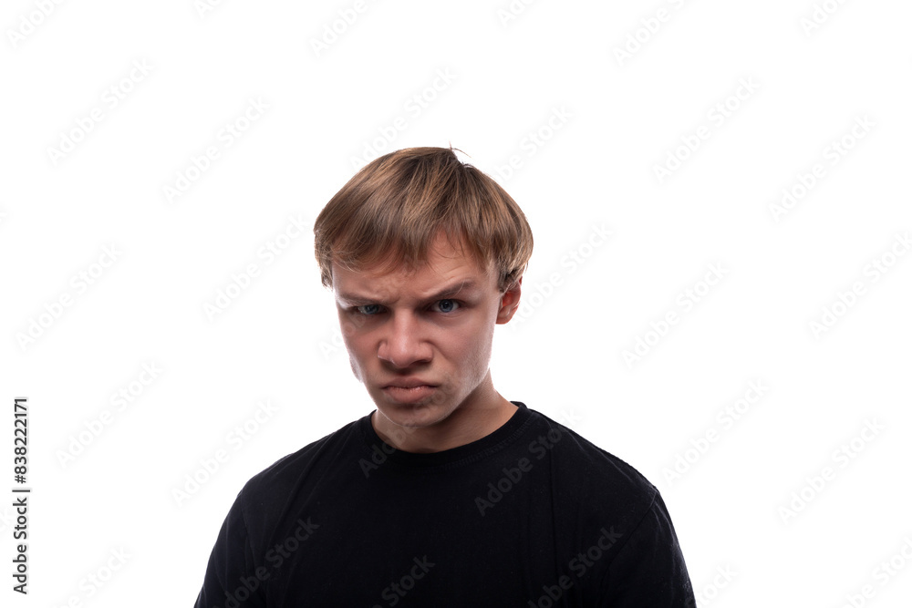 Teen boy dressed in a black T-shirt is angry and suspicious Teen boy dressed in a black T-shirt is angry and suspicious