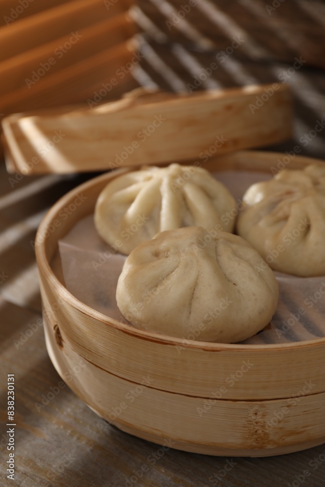Fototapeta premium Delicious bao buns (baozi) on wooden table, closeup