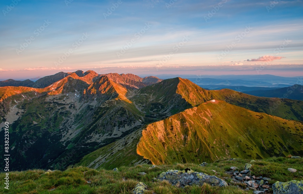 Fototapeta premium Summer in the polish tatra mountains, mountain peaks in Western Tatras mountains in Poland and Slovakia with other peaks scenery, hiking trail, relaxing people on stone and blue sky with clouds.