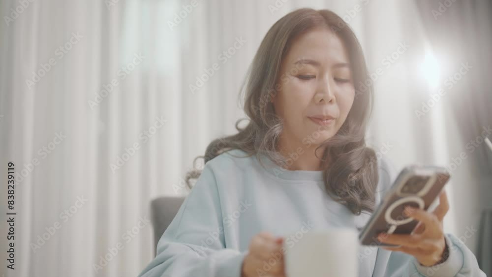 Women are playing with their mobile phones on the sofa and on the dining table and drinking coffee at the same time. Women are playing with their mobile phones on the sofa and on the dining table and drinking coffee at the same time.