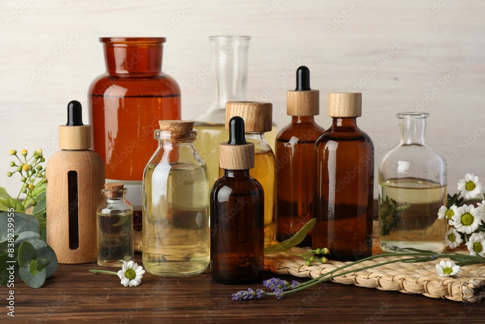 Aromatherapy. Different essential oils and flowers on wooden table Aromatherapy. Different essential oils and flowers on wooden table