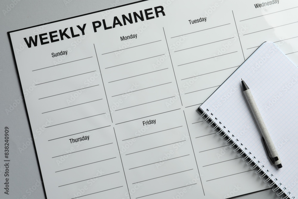 Timetable. Planner, notebook and pen on grey table, top view Timetable. Planner, notebook and pen on grey table, top view