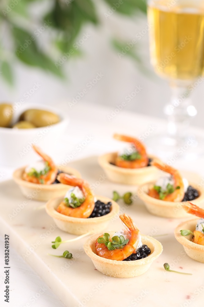 Delicious canapes with shrimps and black caviar on table, closeup Delicious canapes with shrimps and black caviar on table, closeup