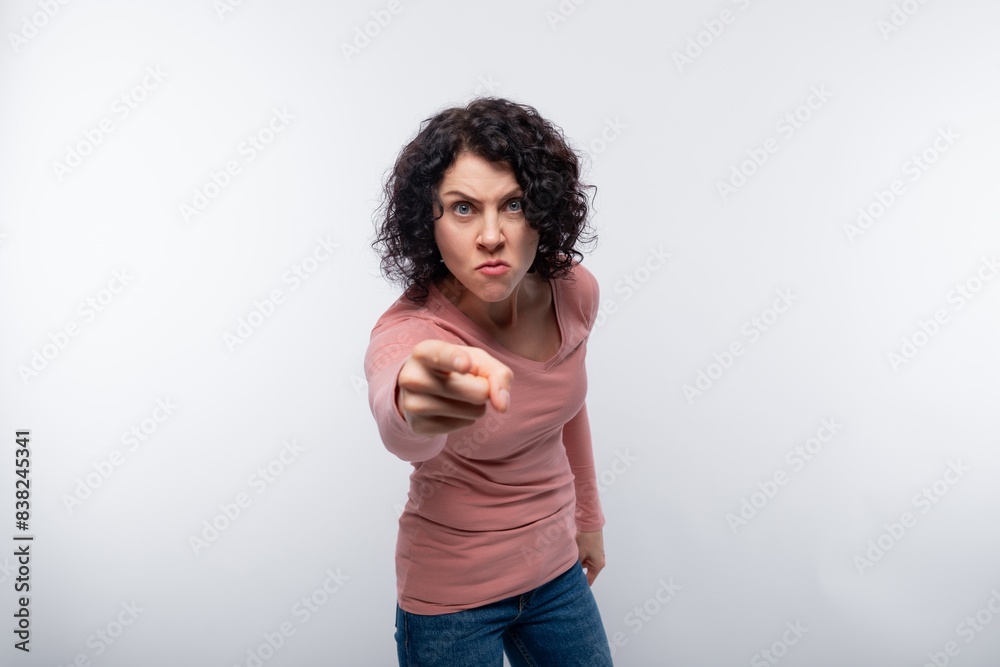 Portrait of an angry curly woman with a short haircut in a pink blouse Portrait of an angry curly woman with a short haircut in a pink blouse