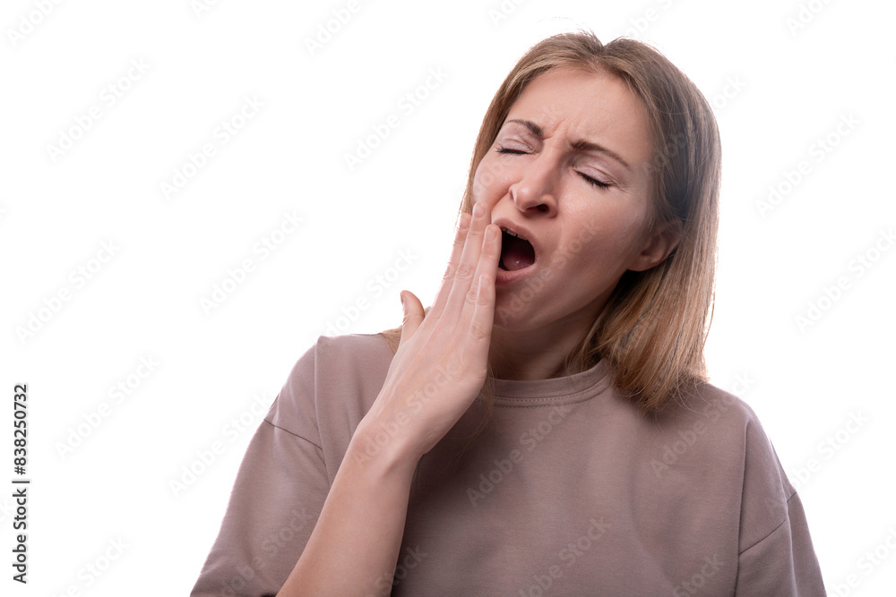 Portrait of a tired European 40 year old woman with flowing blonde hair yawning Portrait of a tired European 40 year old woman with flowing blonde hair yawning