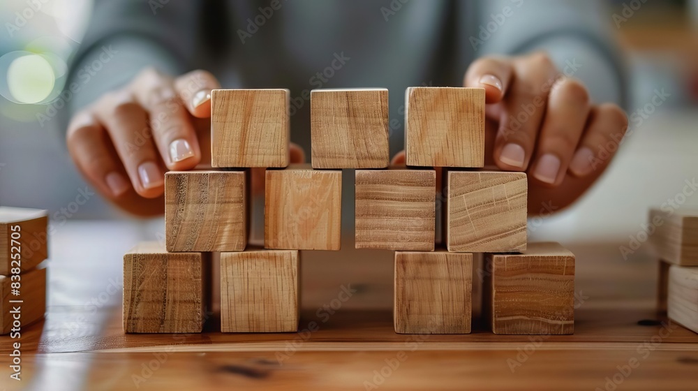 closeup of hands stacking wooden blocks business development and growth concept closeup of hands stacking wooden blocks business development and growth concept
