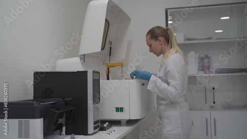 Wallpaper Mural Diagnostic laboratory scientist wearing protective gloves works with a biochemical automated blood analyzer. Lab technician loading blood samples into robotic blood analyzer. Medical equipment.  Torontodigital.ca
