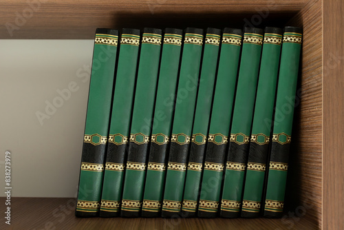 Untitled books on the library shelf, with leather-bound spines showing. Clean anonymous books lined up in the bookcase.