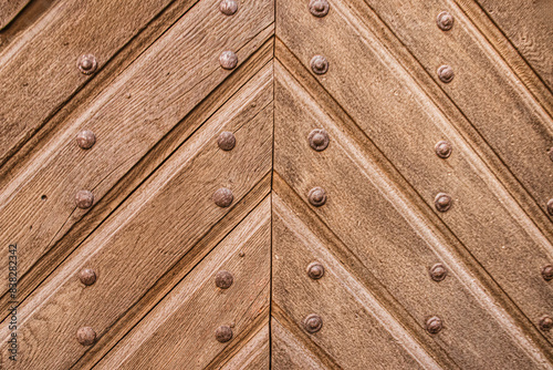 old vintage wooden doors with metal rivets, close-up architectural texture