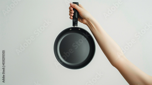 Woman's hand holding a frying pan, clearly visible detail of the hand with the black frying pan, Ai generated images