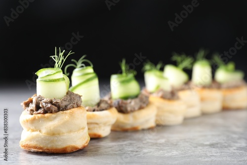 Delicious puff pastry with mushrooms, cucumber and dill on grey table photo