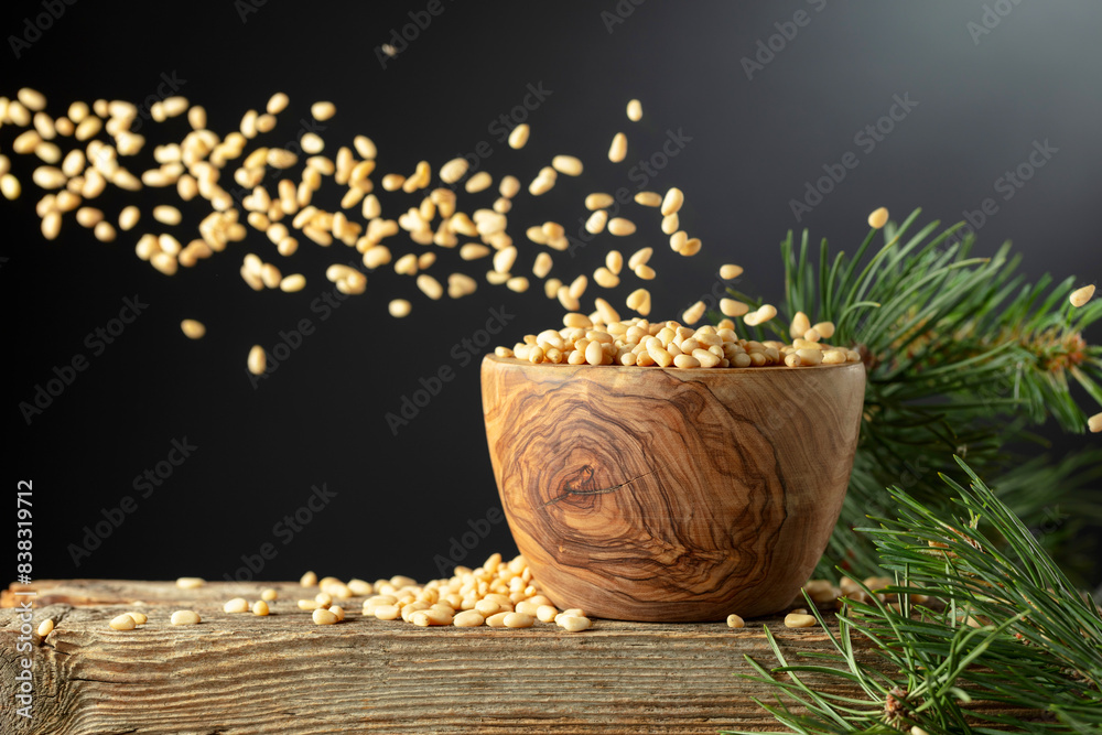 Nuts in a wooden bowl and cedar branch on a old wooden table. Nuts in a wooden bowl and cedar branch on a old wooden table.