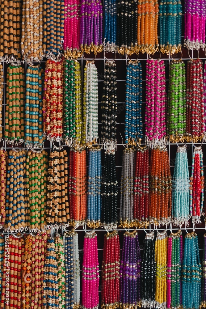 Vertical shot of colorful beaded bracelets hanging on a wall in a shop in Pakistan