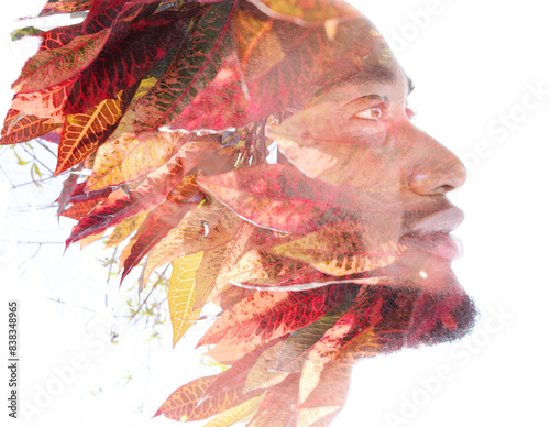 A double exposure profile portrait of a smiling man in red and yellow colors