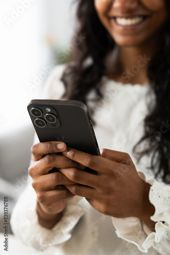 Unrecognisable black woman using phone. Closeup of hands holding mobile.