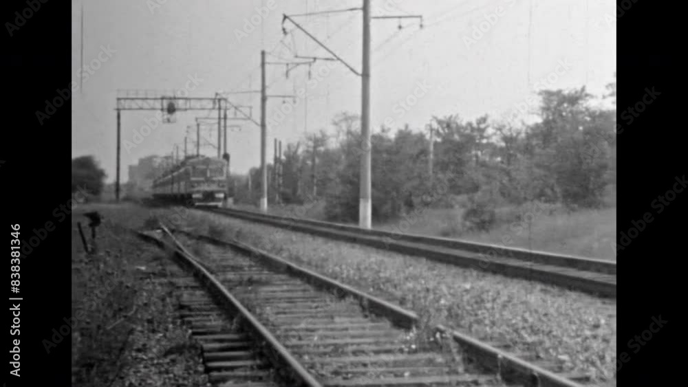 Boy moving railway change equipment, close up. Retro black white film. Manual shifting of metal rail road. Children games danger near industrial railroad. Vintage old 1980s archive. Train track move Boy moving railway change equipment, close up. Retro black white film. Manual shifting of metal rail road. Children games danger near industrial railroad. Vintage old 1980s archive. Train track move