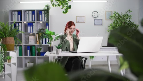 eco-friendly office, young businesswoman working on a computer in a room with green plants photo
