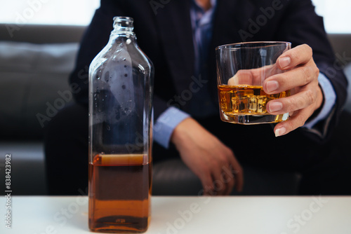 Foto businessman sits and holds glass of liquor in his hand to drink relieve stress after experiencing problems in business