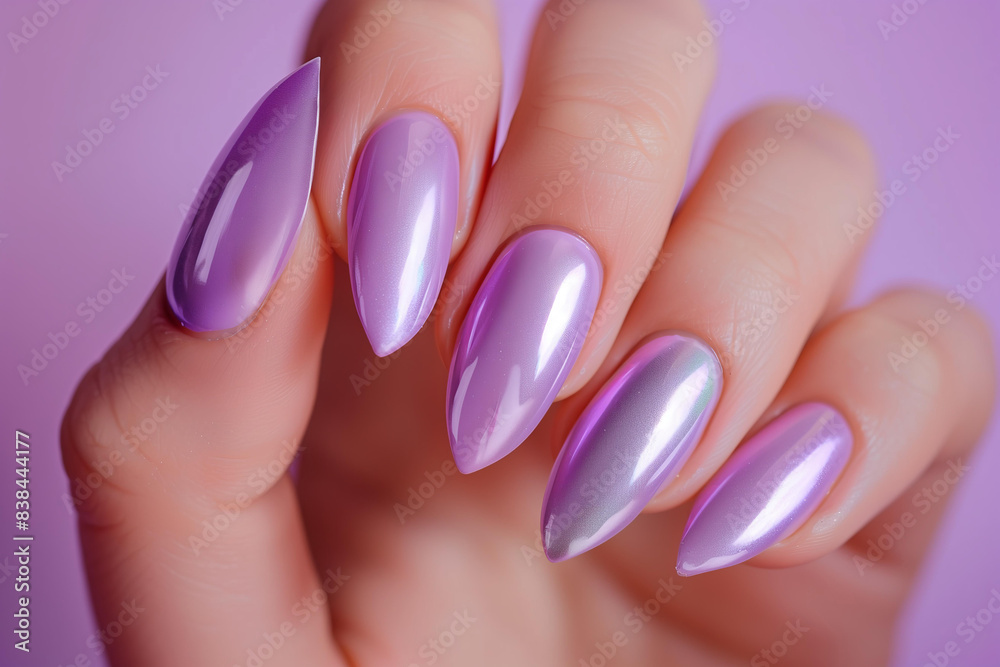 close up perfect almond shaped manicure in metallic pastel lavender color, ivory solid color background close up perfect almond shaped manicure in metallic pastel lavender color, ivory solid color background