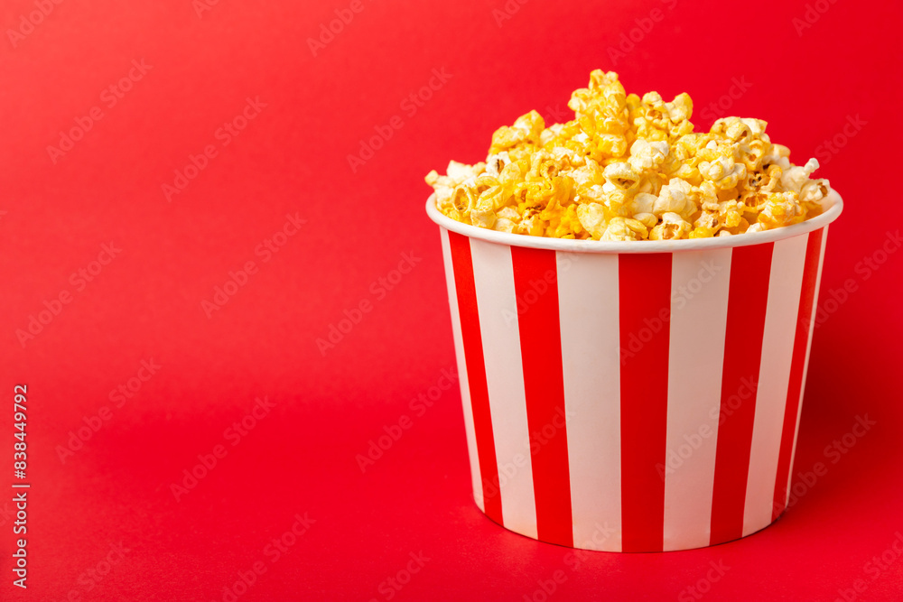 Popcorn box. Red and white striped buckets of popcorn on a red background. Cinema and entertainment concept. Movie night with popcorn. Cheesy popcorn. Delicious appetizer, snack. Place for text. Popcorn box. Red and white striped buckets of popcorn on a red background. Cinema and entertainment concept. Movie night with popcorn. Cheesy popcorn. Delicious appetizer, snack. Place for text.