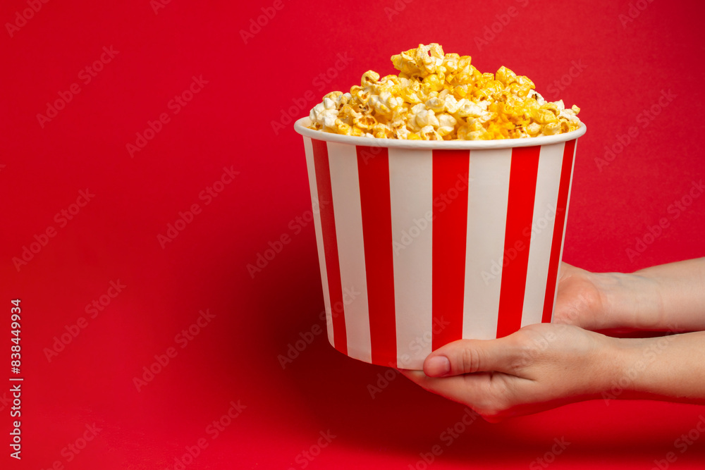 Popcorn box. Red and white striped buckets of popcorn on a red background. Cinema and entertainment concept. Movie night with popcorn. Cheesy popcorn. Delicious appetizer, snack. Place for text. Popcorn box. Red and white striped buckets of popcorn on a red background. Cinema and entertainment concept. Movie night with popcorn. Cheesy popcorn. Delicious appetizer, snack. Place for text.