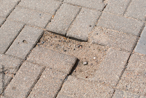 Obraz na płótnie Sidewalk with pothole. Defects on paving slabs, improperly laid paving stones. Inferior or insufficient bedding sand might cause pavers to move and break. Paving failure, improperly laid paving stones w salonie