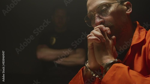 Orange jumpsuit wearing informant answering questions photo