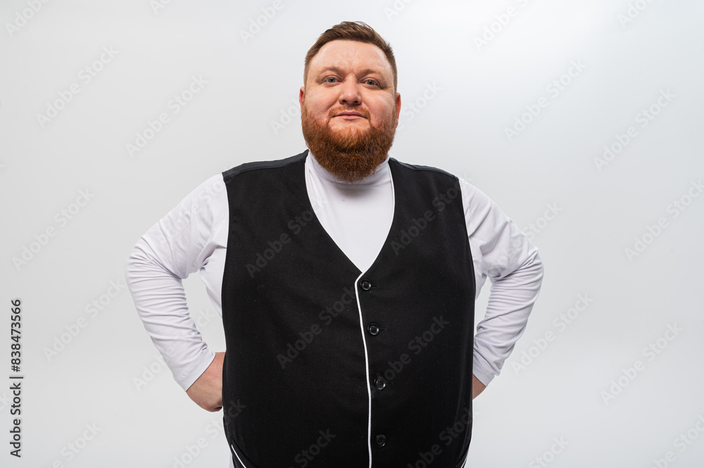 Fototapeta premium Hey you! Portrait of a happy, emotional bearded man in a light t-shirt and a black vest on a light background. Studio shot.