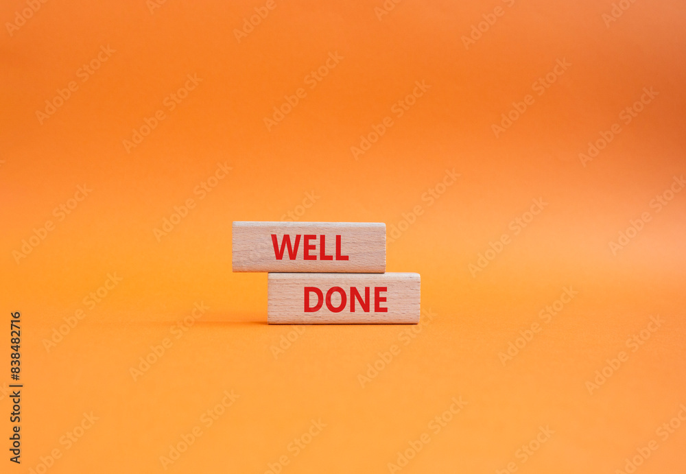 Naklejka premium Well done symbol. Wooden blocks with words Well done. Beautiful orange background. Business and Well done concept. Copy space.