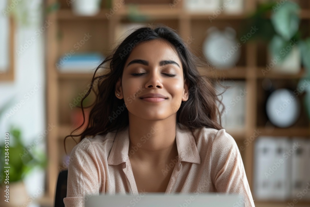 Female smiling, seated at table, using laptop Female smiling, seated at table, using laptop