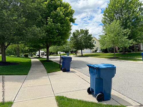 Blue trash cans line the street on trash day in an Indiana Neighborhood with copy space.