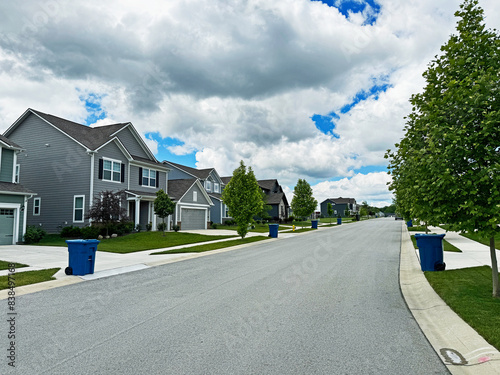 Blue trash cans line the street on trash day in an Indiana Neighborhood with copy space.