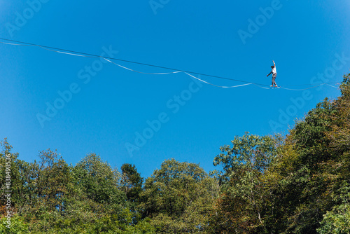 un funambule dans la nature. Funambule en extérieur naturel. Acrobate sur un fil en hauteur. Funambule sur une corde tendue. Funambulisme dehors.. Equilibre photo