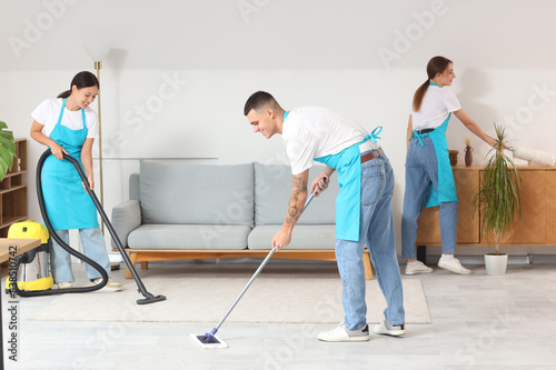 Team of young janitors clea...