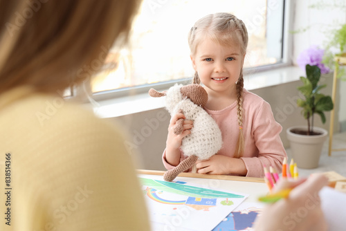 Little girl with toy sittin...